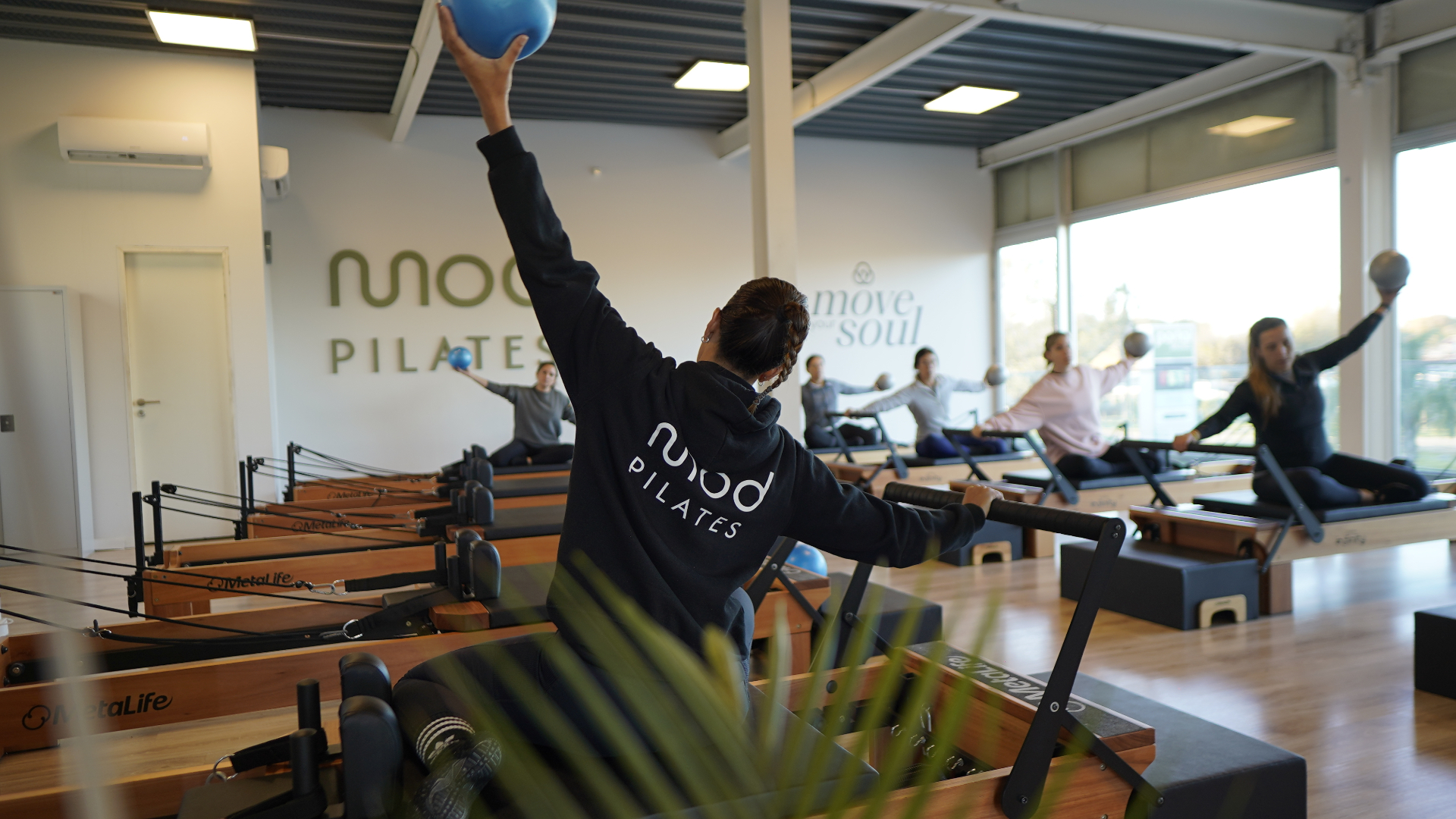 Mujer en clase de Pilates Reformer en estudio boutique de Mod Pilates